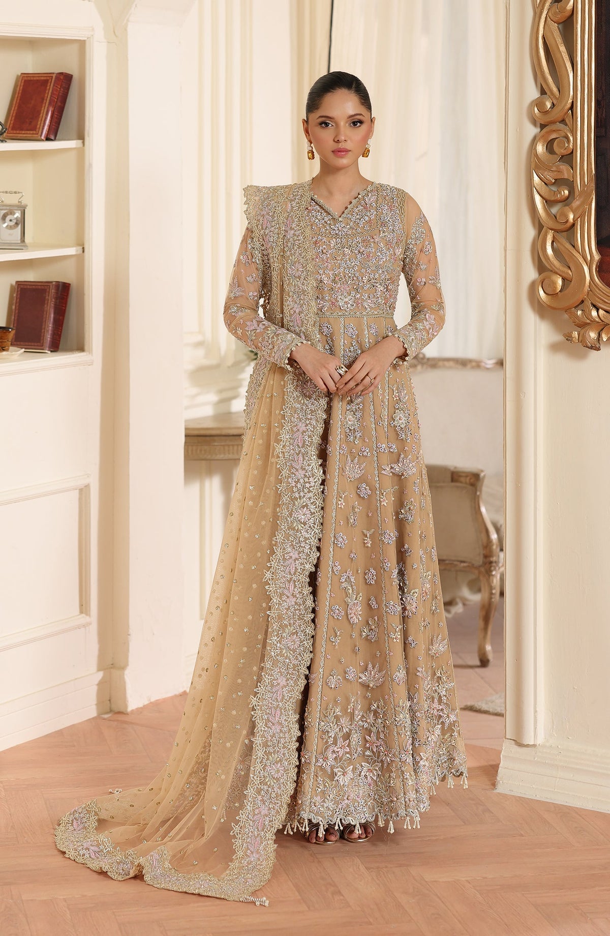 Woman in a traditional embroidered dress standing in a decorated room.