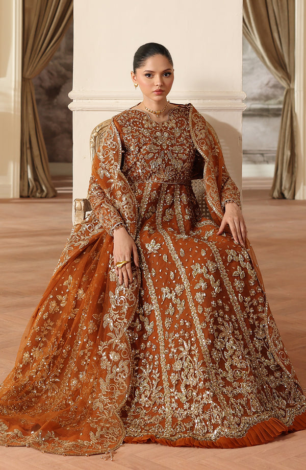 Woman in a traditional embroidered outfit sitting in a decorated room.
